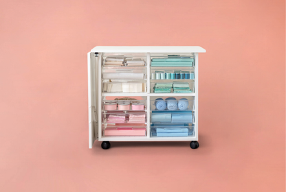 Storage cart with colorful compartments on a pink background