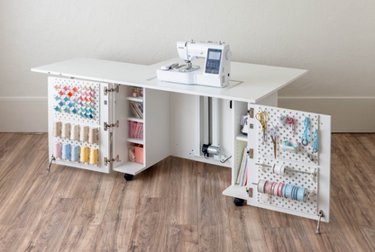 White sewing station with various sewing supplies on a wooden floor. [Deluxe]