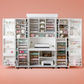 DreamBox - A white DreamBox storage system with various compartments and shelves, partially filled with items, set against a pink background. - 25790857117758