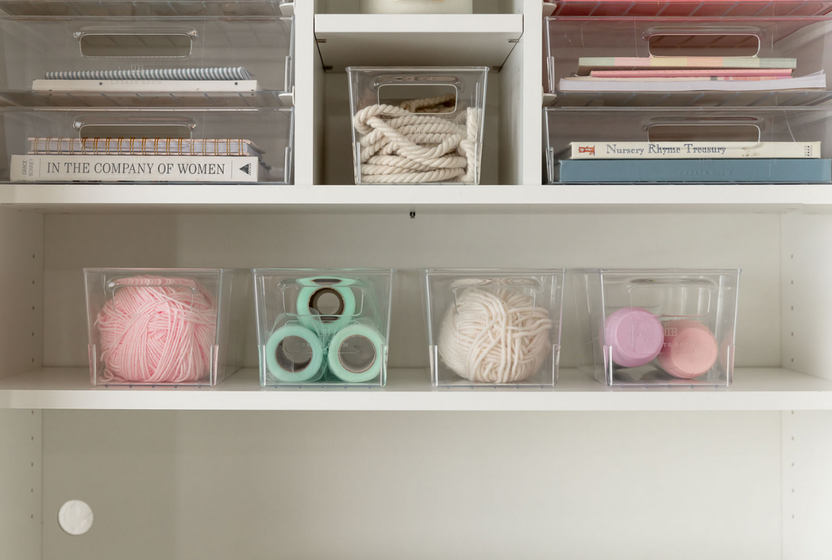 Wolle und Tüll in klaren Behältern im Schrank